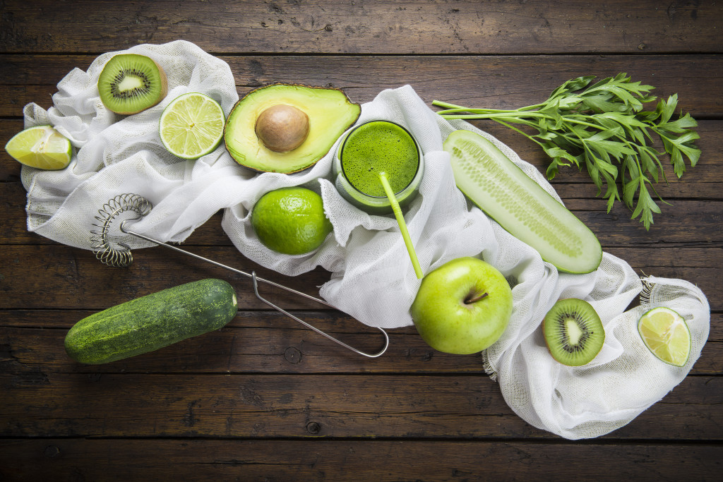 Batido verde o green smoothie con frutas y verduras en la mesa de la cocina para una dieta saludable